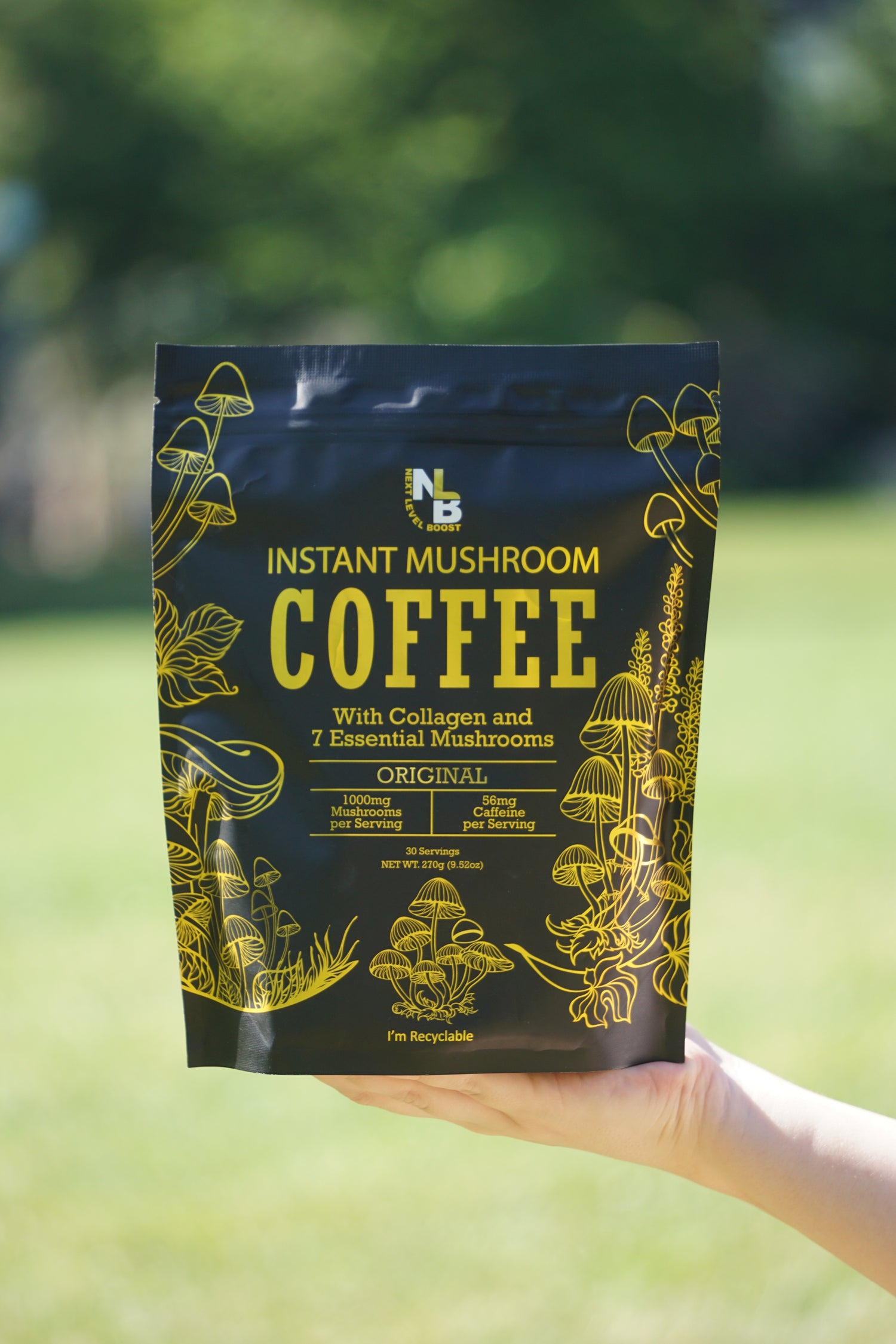 Hand holding a package of instant mushroom coffee with a blurred green background