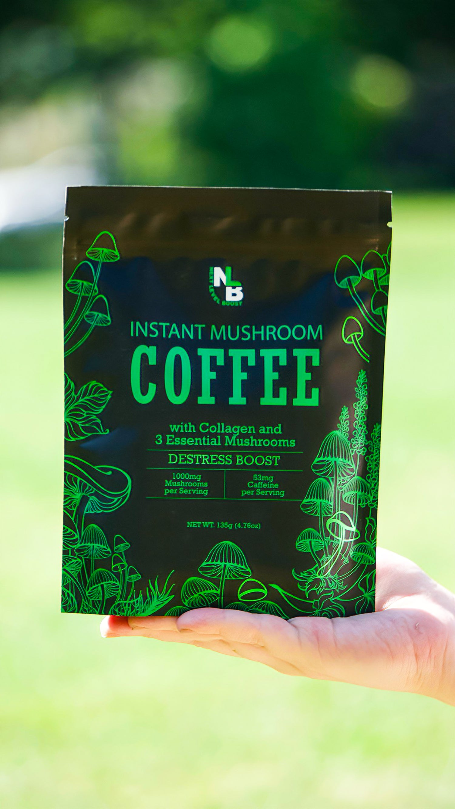 Hand holding a package of instant mushroom coffee with a green label against a blurred natural background