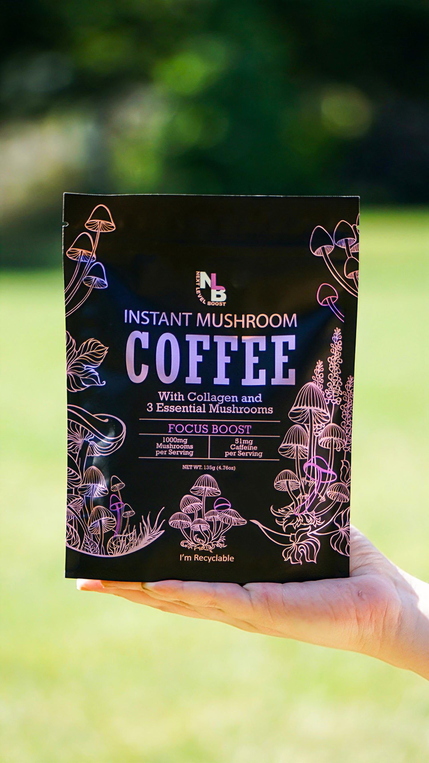 Hand holding a package of instant mushroom coffee with a blurred green background