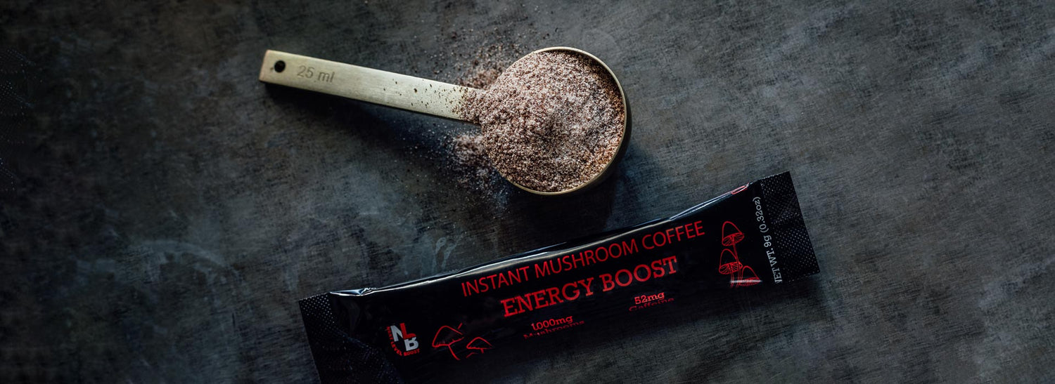 Scoop of instant mushroom coffee powder next to a Next Level Boost Energy Boost instant mushroom coffee package.