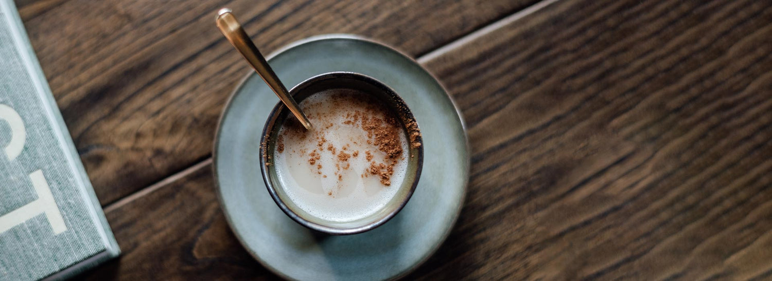 Cup of mushroom coffee with spoon on rustic wood table – functional coffee aesthetic