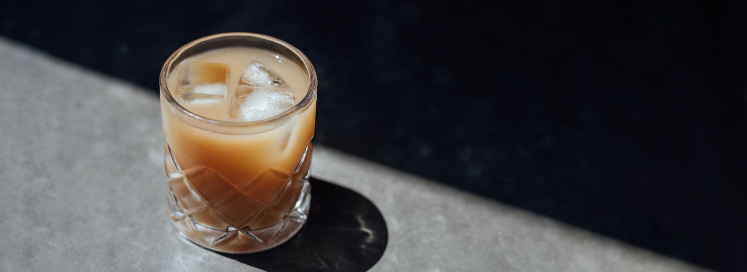 Iced mushroom coffee in a glass with ice cubes on a wooden surface