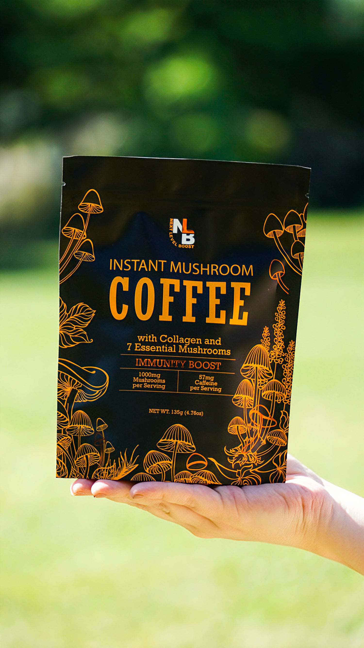 Hand holding a package of Instant Mushroom Coffee with a blurred green background